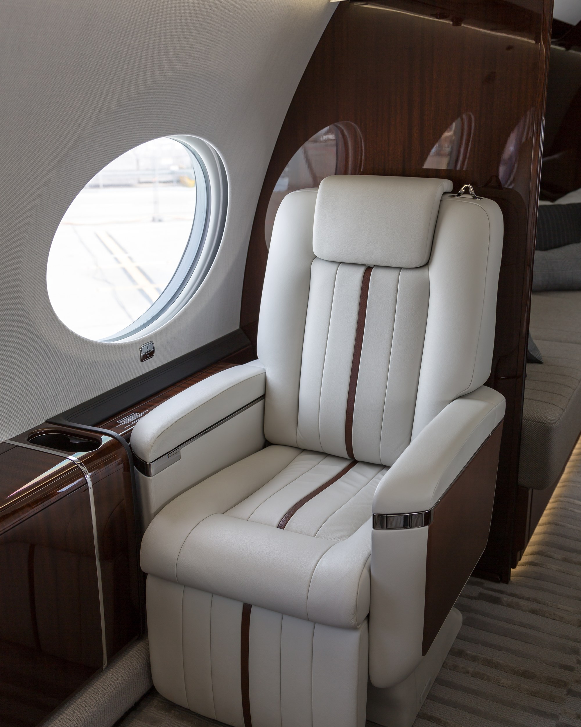 The cream leather and polished mahogany cabin of a private long-range jet